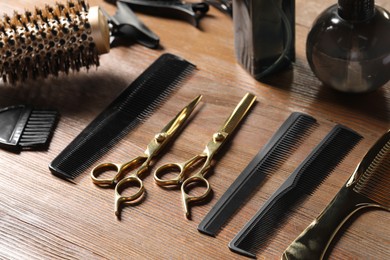 Hairdresser tools. Different scissors and combs on wooden table