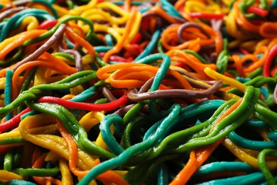 Photo of Spaghetti painted with different food colorings as background, closeup