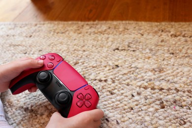 Photo of Child playing video games with controller indoors, closeup. Space for text