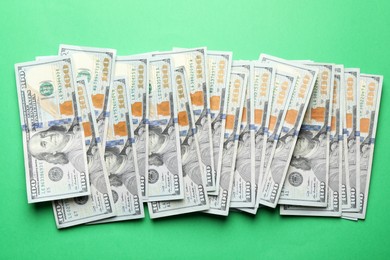 Many dollar banknotes on green background, flat lay