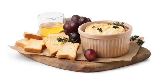 Photo of Tasty baked camembert in bowl, croutons, grapes, honey and thyme on white background
