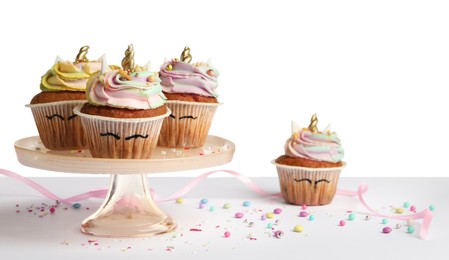 Photo of Dessert stand with cute sweet unicorn cupcakes isolated on white
