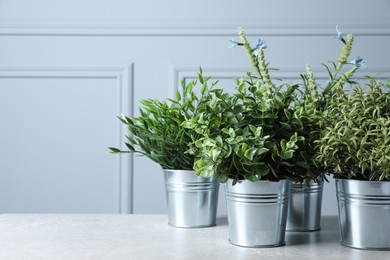 Photo of Different aromatic potted herbs on light table, space for text