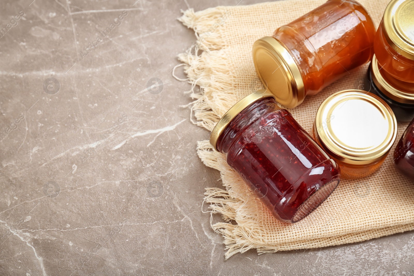 Photo of Jars with different sweet jam on table