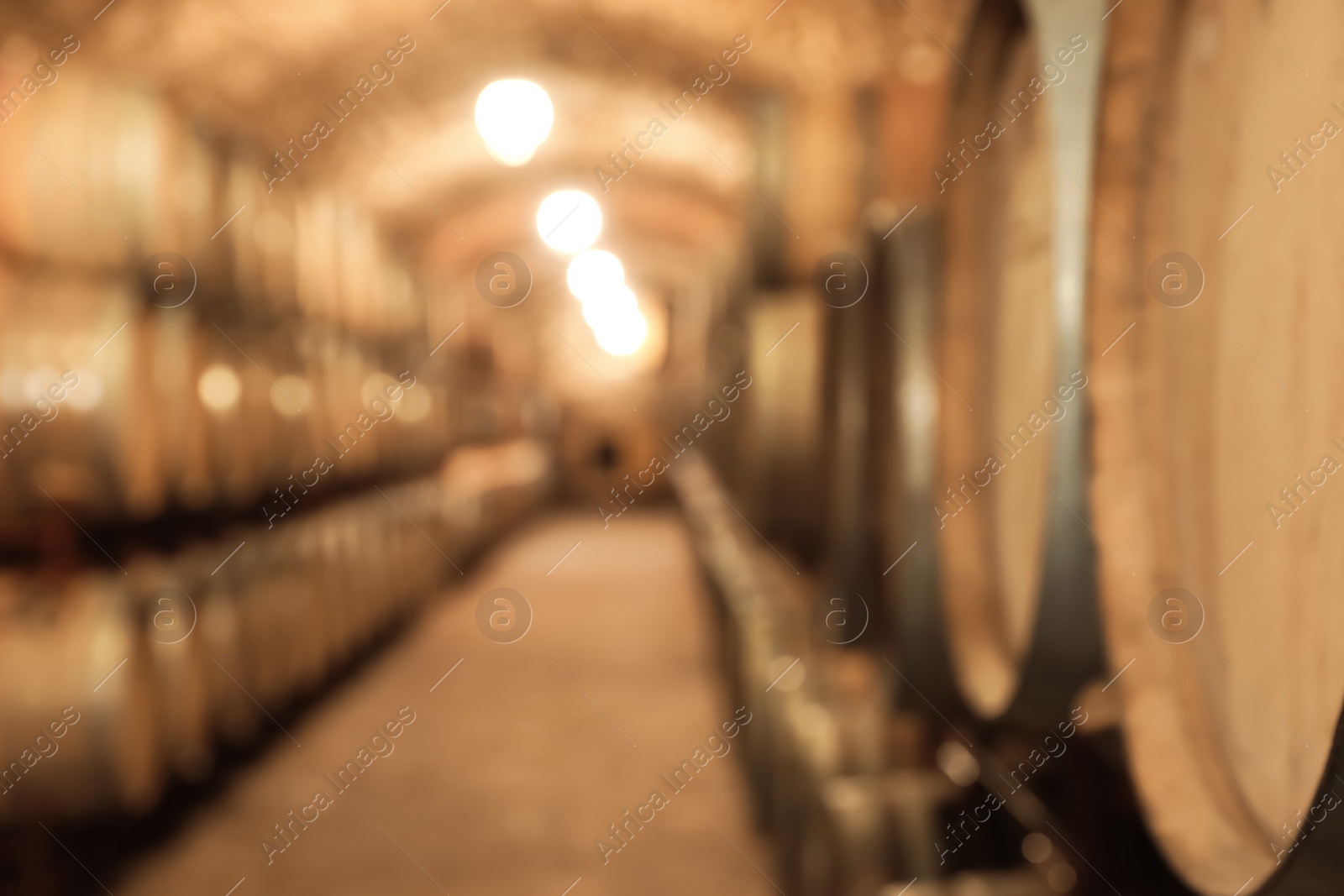 Photo of Blurred view of wine cellar with large wooden barrels