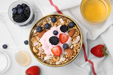 Photo of Tasty granola, yogurt and fresh berries served on white tiled table, flat lay. Healthy breakfast