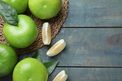 Fresh ripe sweetie fruits on blue wooden table, flat lay. Space for text