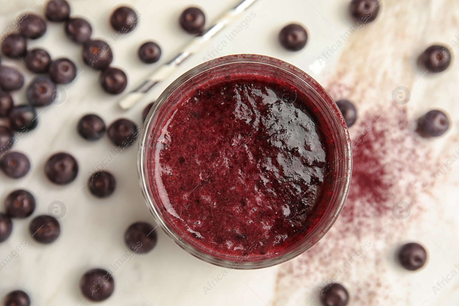 Photo of Glass with delicious acai smoothie on table, top view