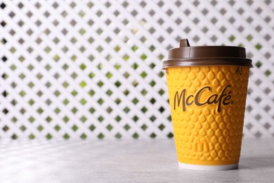 Photo of MYKOLAIV, UKRAINE - AUGUST 12, 2021: Hot McDonald's drink on grey table. Space for text