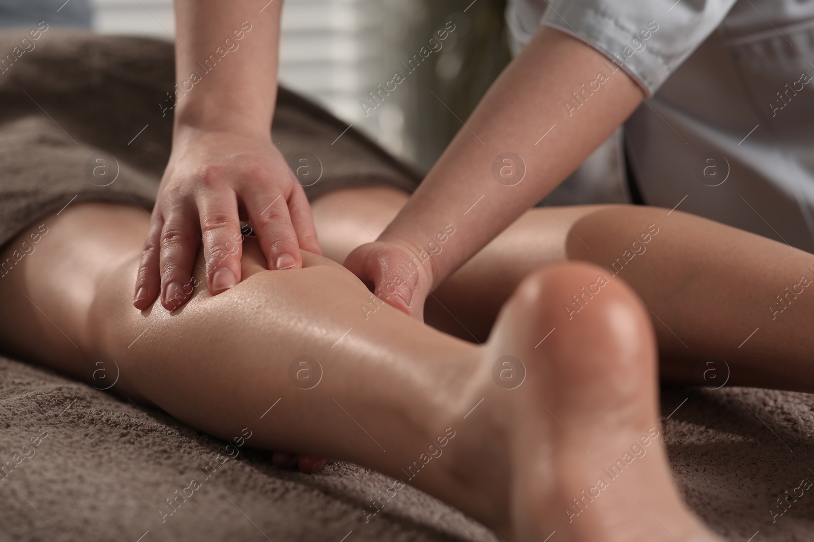 Photo of Woman receiving leg massage in spa salon, closeup