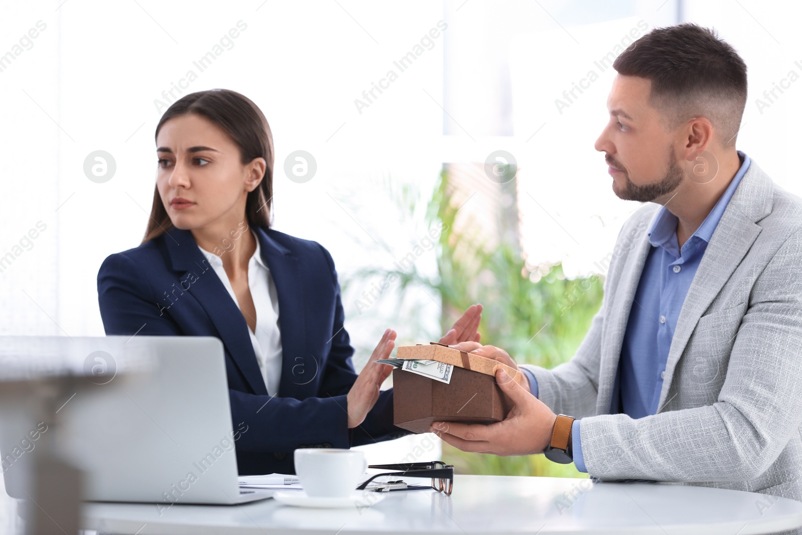 Photo of Businesswoman refusing to take bribe at table indoors