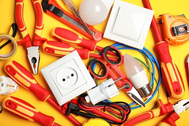 Set of electrician's tools on color background, top view