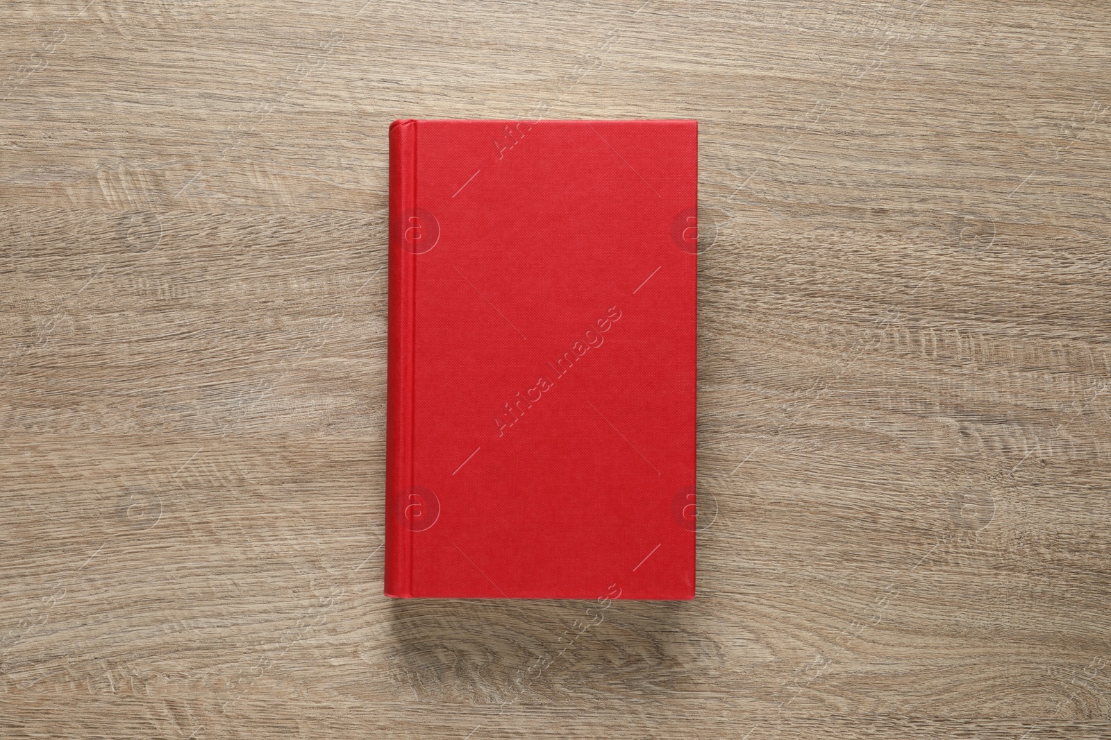 Photo of Closed hardcover book on wooden table, top view