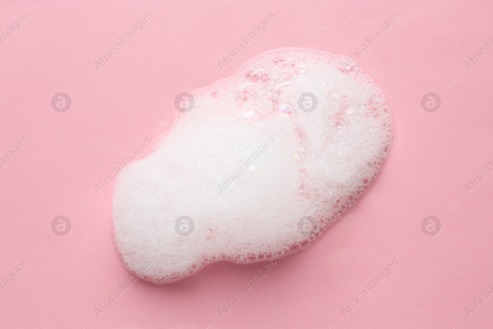 Photo of Drop of bath foam on pink background, top view