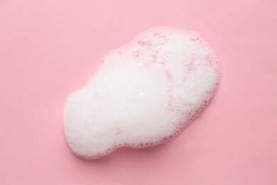 Photo of Drop of bath foam on pink background, top view