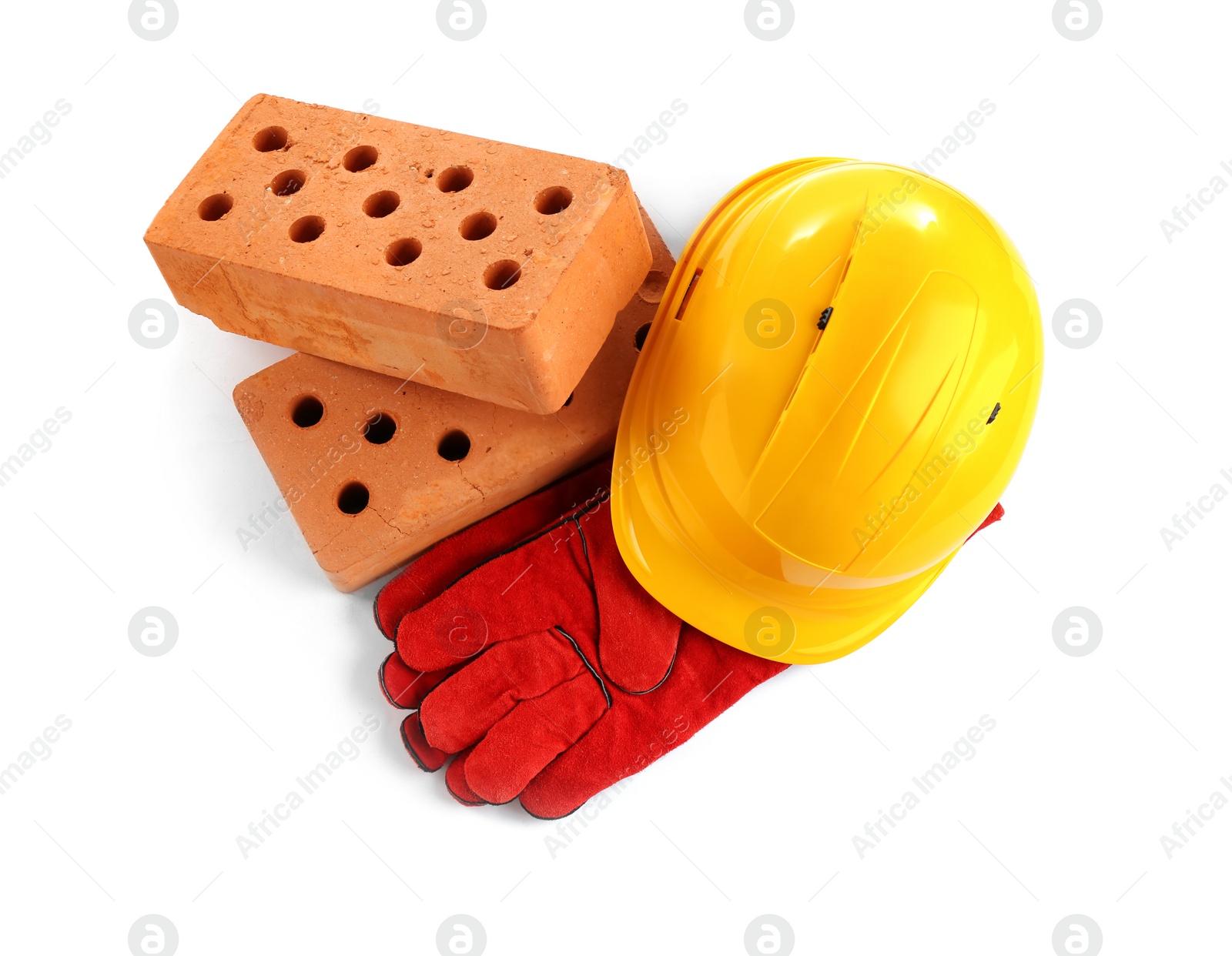 Photo of Hard hat, gloves and bricks on white background, top view. Construction industry