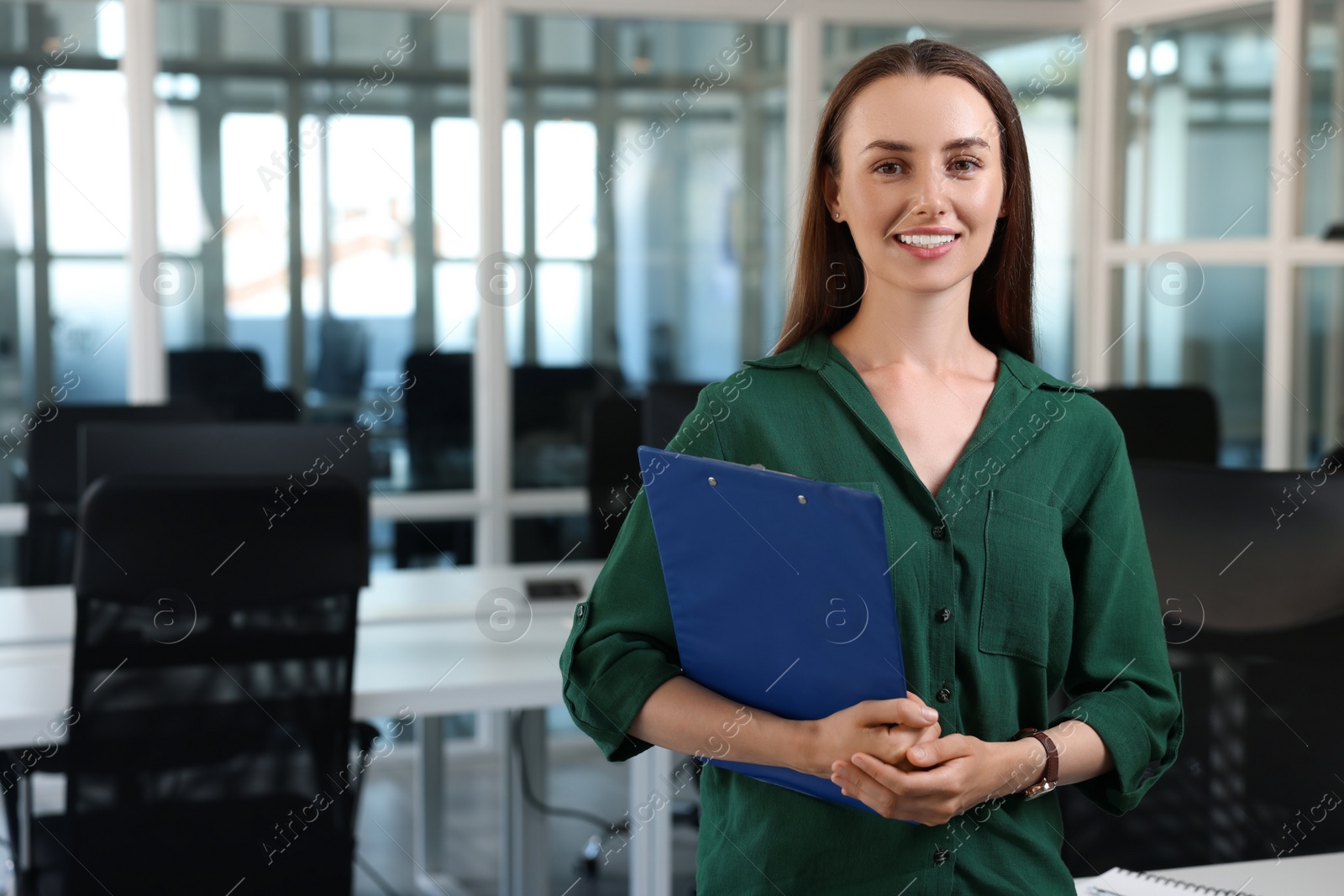 Photo of Happy woman with clipboard in office, space for text