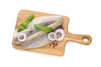 Photo of Wooden board with delicious salted herring fillets, onion rings, peppercorns and basil isolated on white, top view