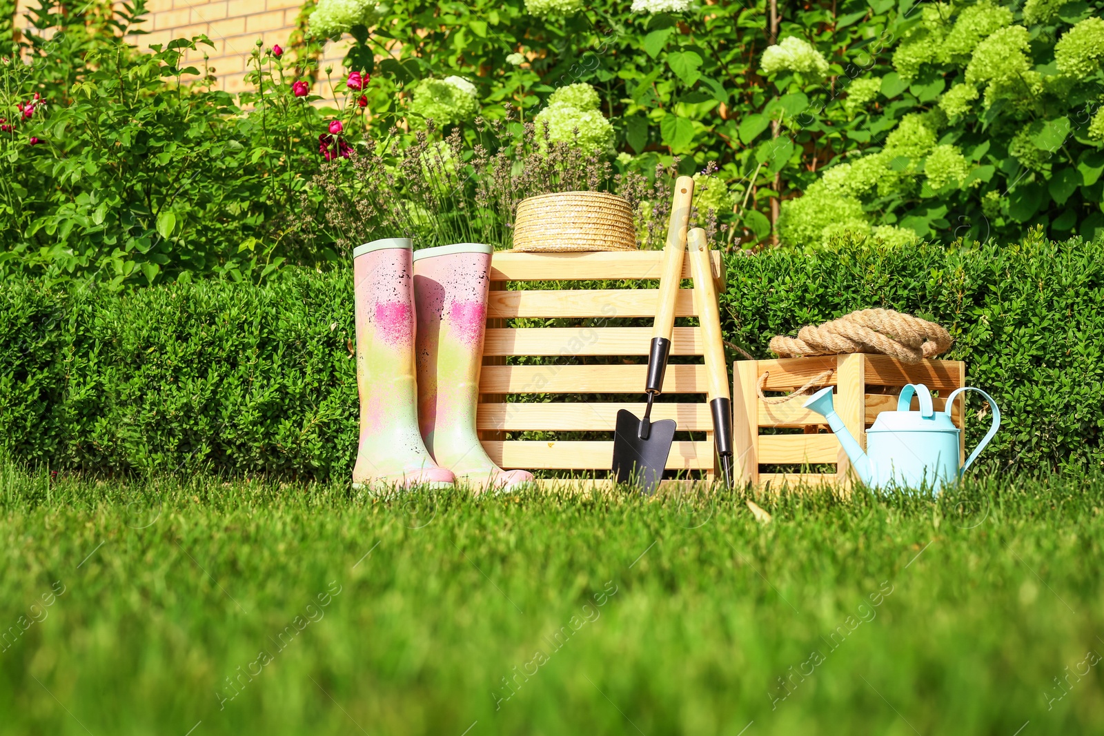 Photo of Wooden crates and gardening tools at backyard