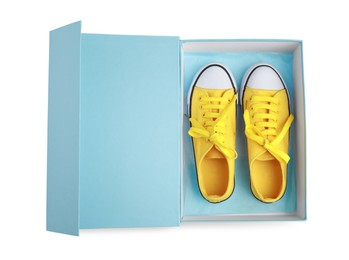 Pair of stylish yellow shoes in turquoise box on white background, top view