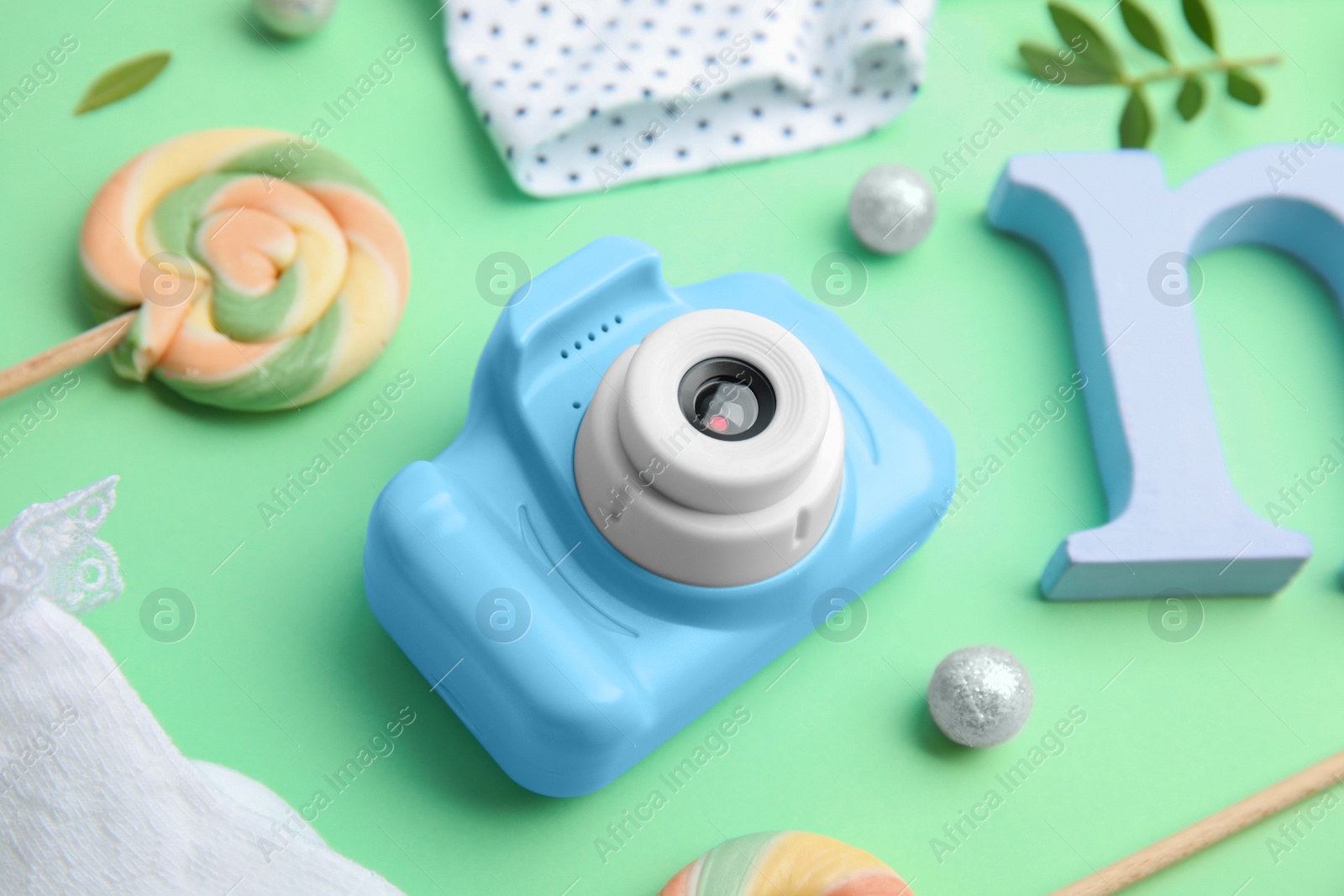 Photo of Light blue toy camera on light green background. Future photographer