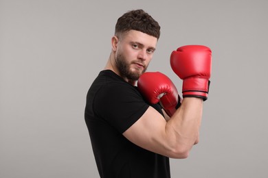 Photo of Man in boxing gloves on grey background