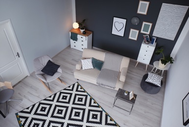 Photo of Living room interior with comfortable sofa and rocking chair, view through CCTV camera