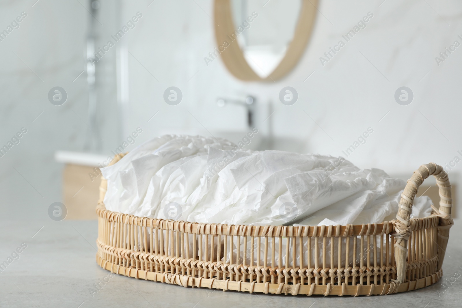 Photo of Basket with baby diapers on counter in bathroom