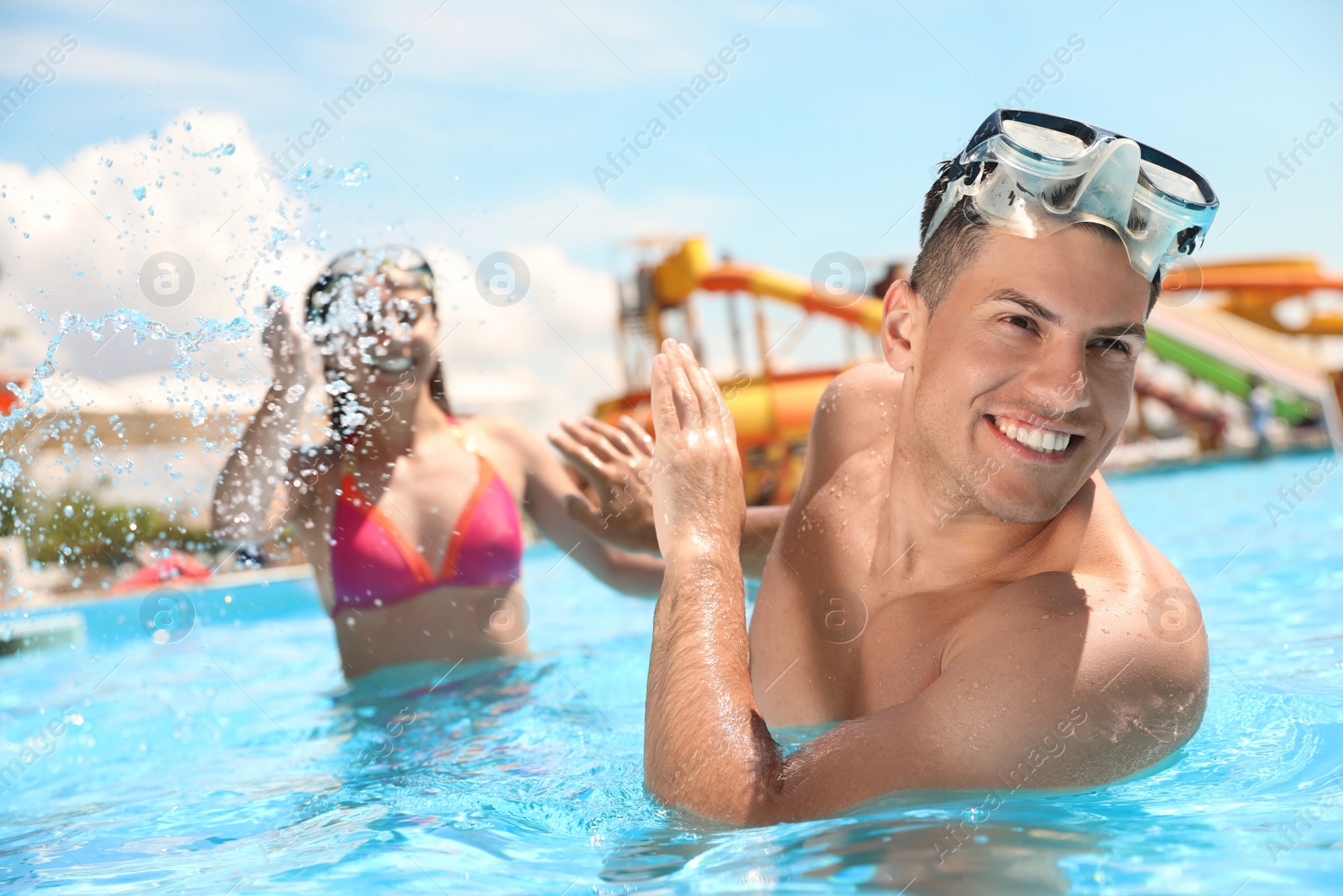 Photo of Happy couple having fun in swimming pool. Summer vacation