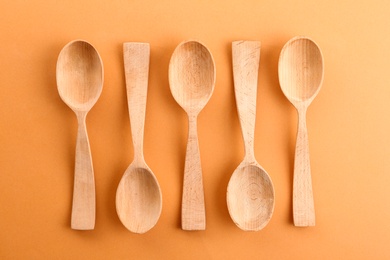 Photo of Flat lay composition with clean wooden spoons on color background