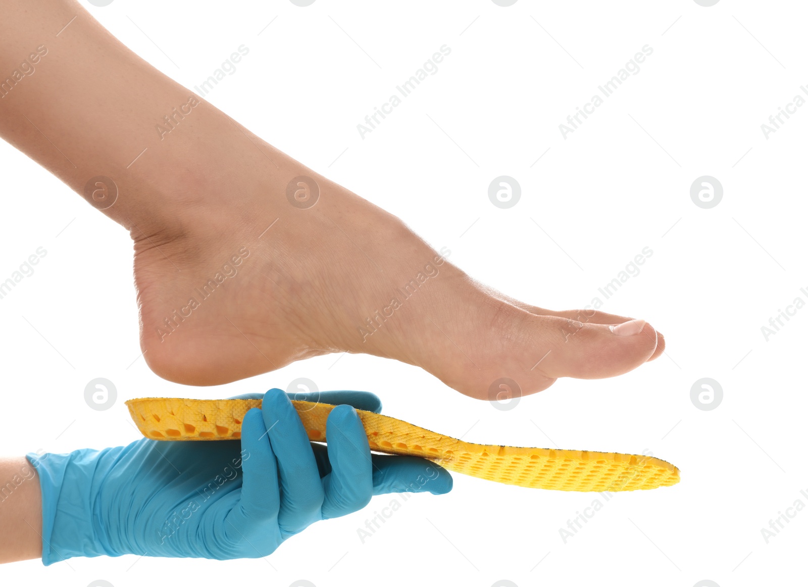 Photo of Orthopedist fitting insole on patient's foot against white background, closeup