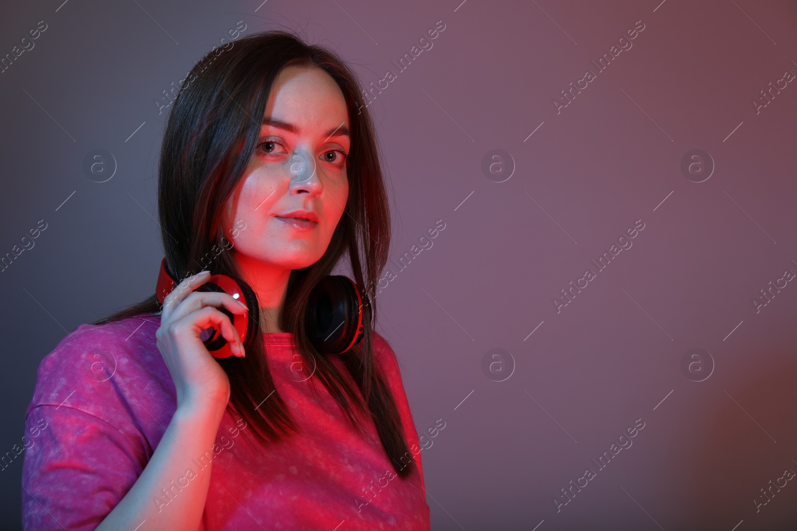 Photo of Portrait of beautiful woman with headphones on color background, space for text