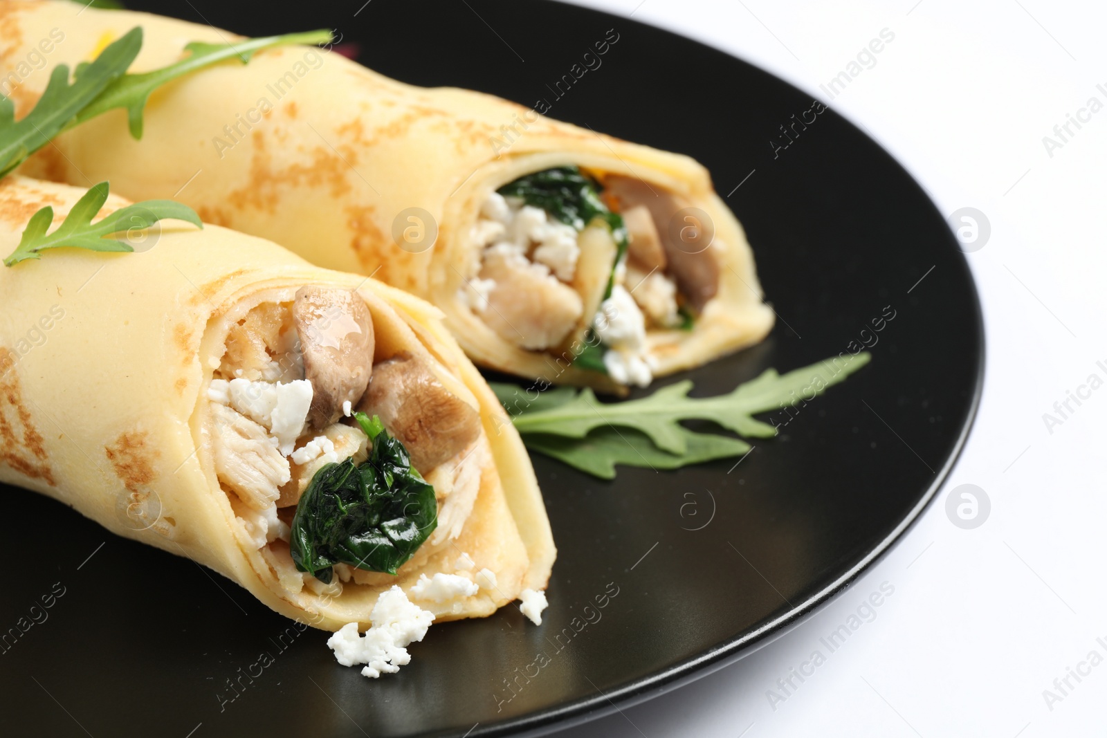 Photo of Delicious thin pancakes with chicken and mushrooms isolated on white, closeup