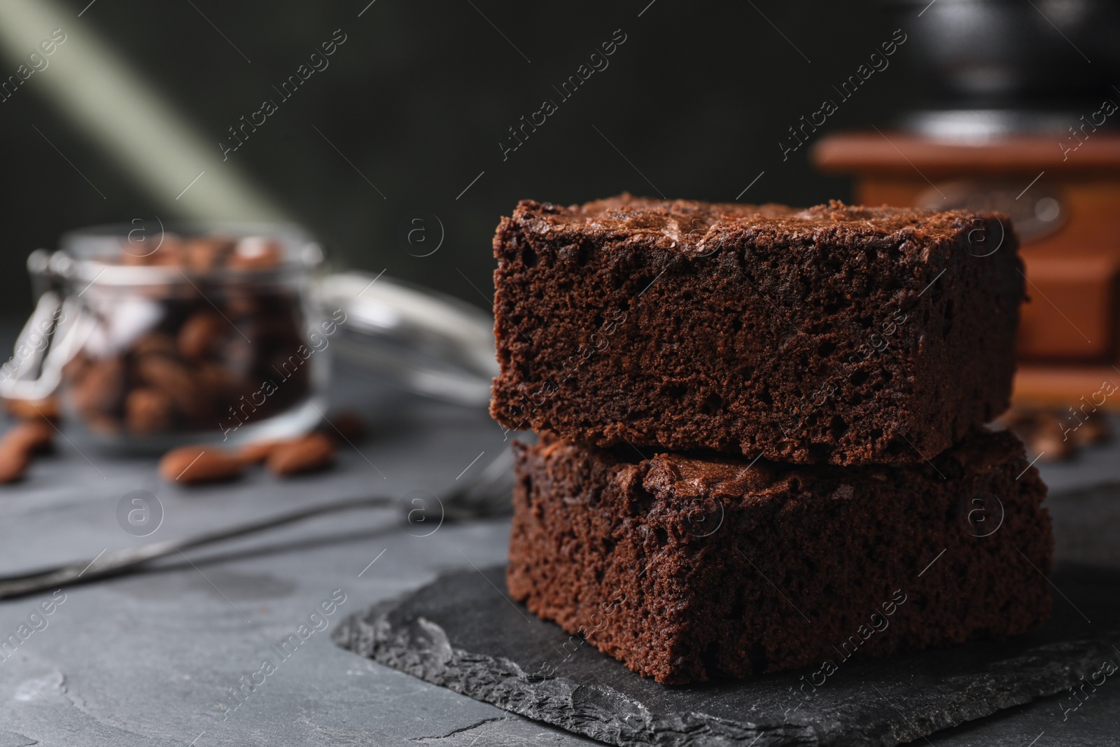 Photo of Slate board with fresh brownies on grey table, space for text. Delicious chocolate pie