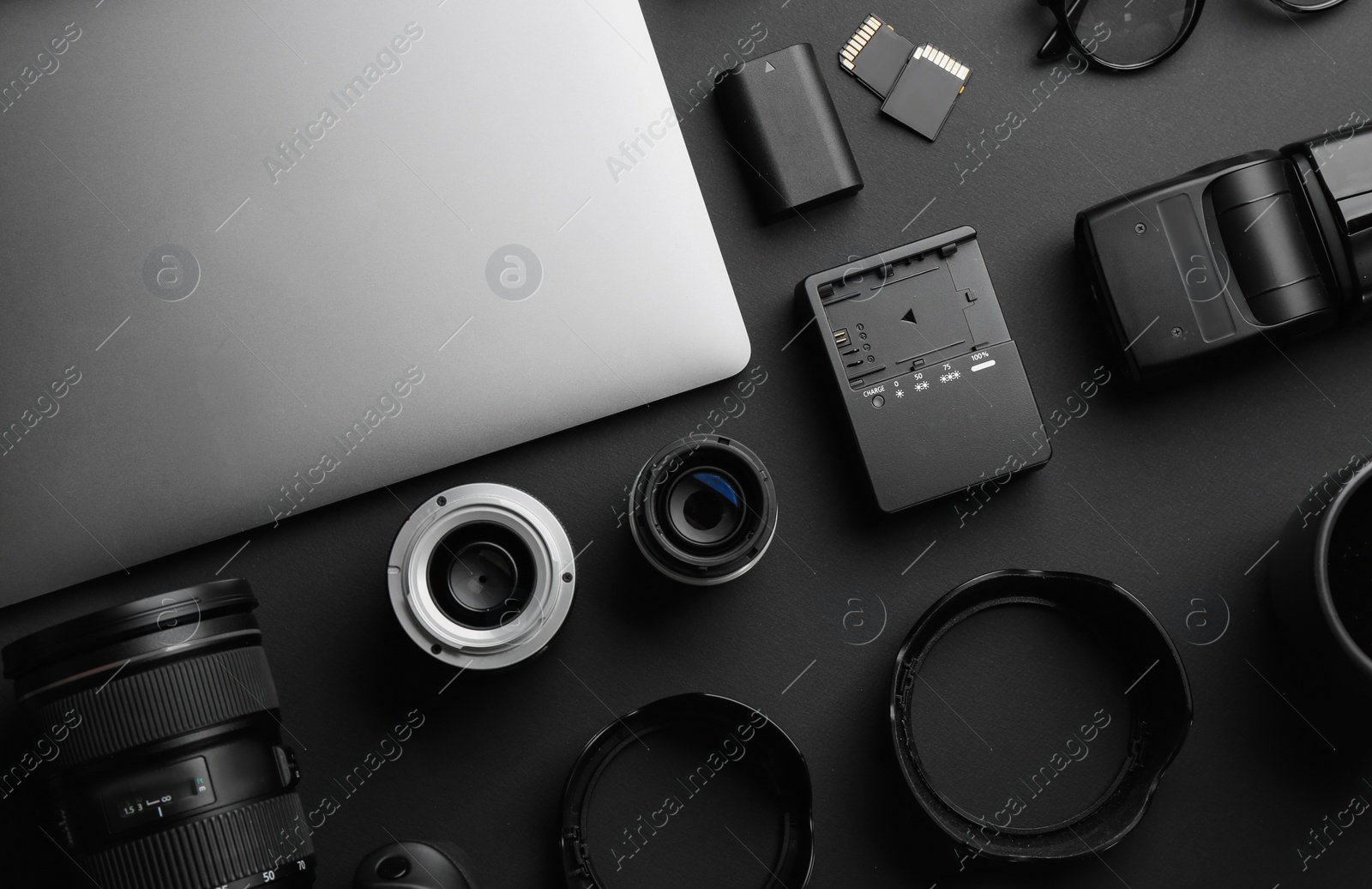 Photo of Flat lay composition with professional photographer equipment on dark background