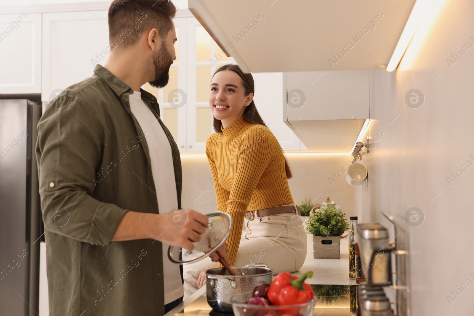 Photo of Lovely young couple cooking together in kitchen