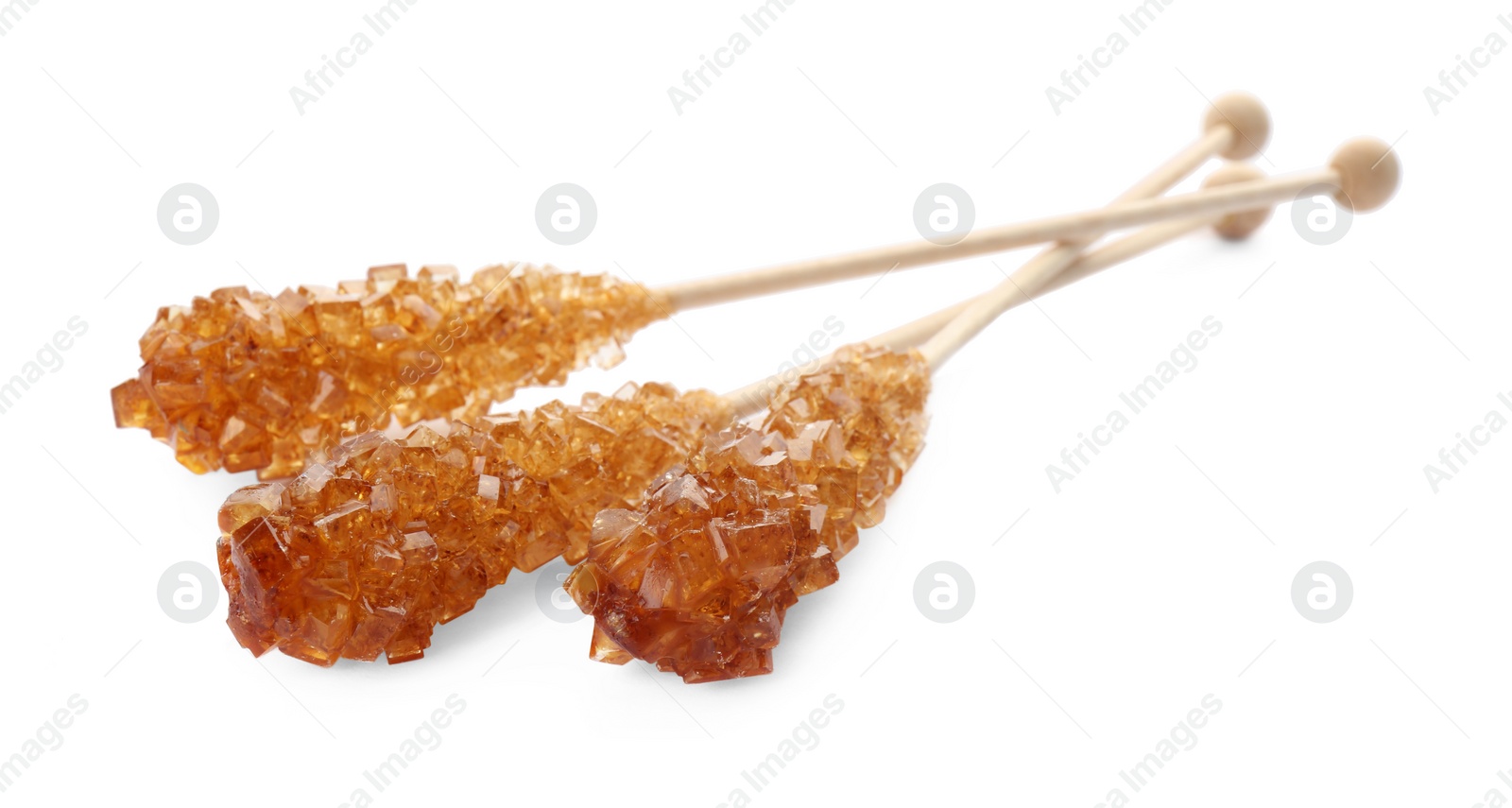 Photo of Wooden sticks with sugar crystals isolated on white. Tasty rock candies