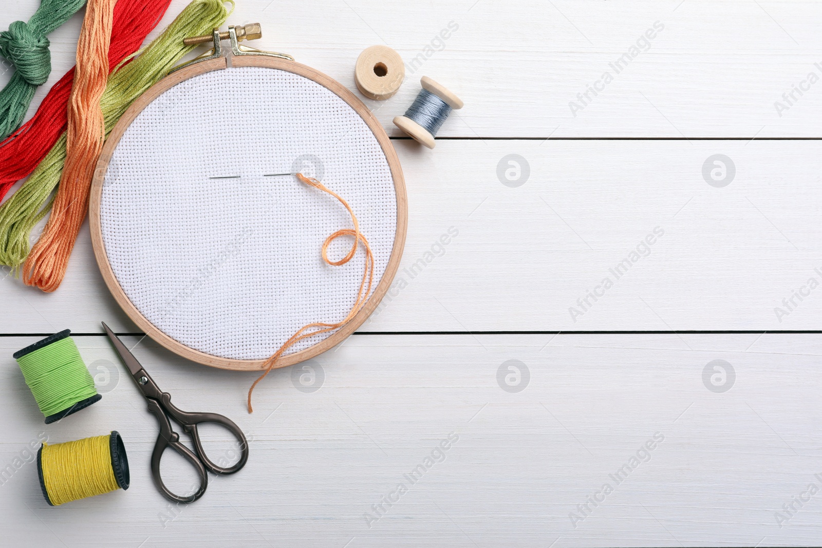 Photo of Set of embroidery equipment on white wooden table, flat lay. Space for text