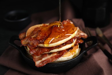 Photo of Delicious pancakes with maple syrup and fried bacon on table, closeup