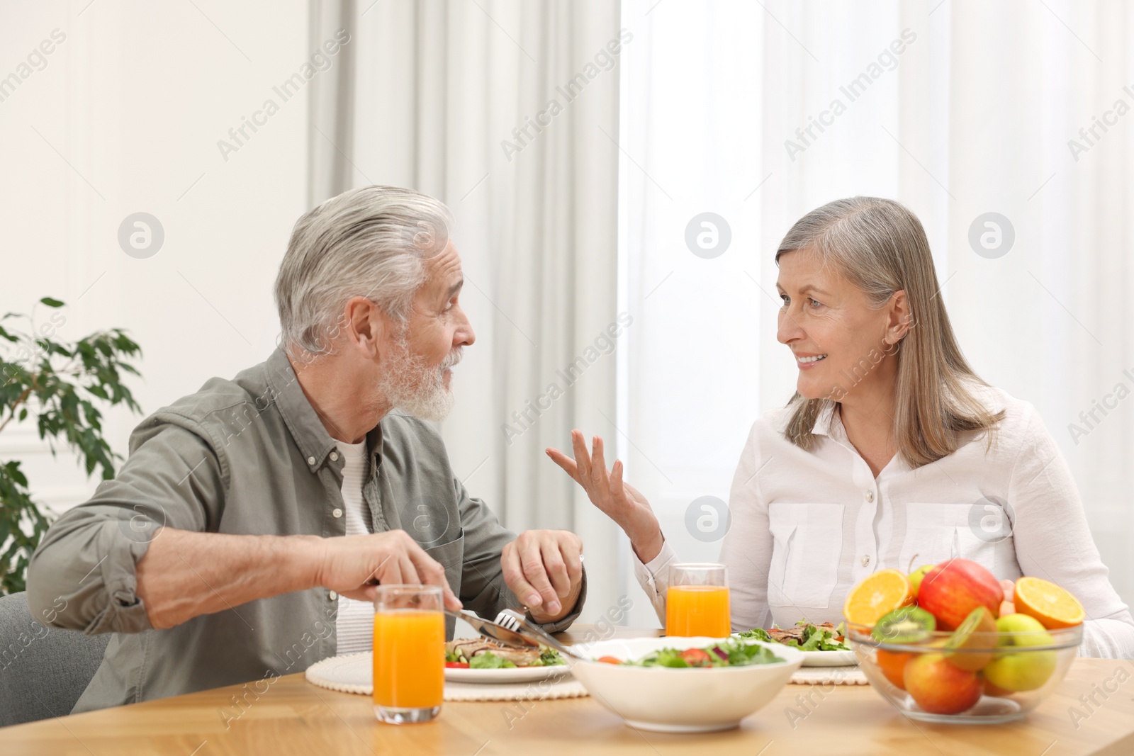 Photo of Happy senior couple having dinner at home