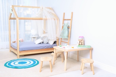 Photo of View of cozy child's room interior with cute bed