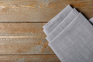 Grey hemp cloth on wooden table, top view. Space for text