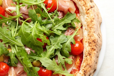 Photo of Tasty pizza with meat and arugula on white table, top view