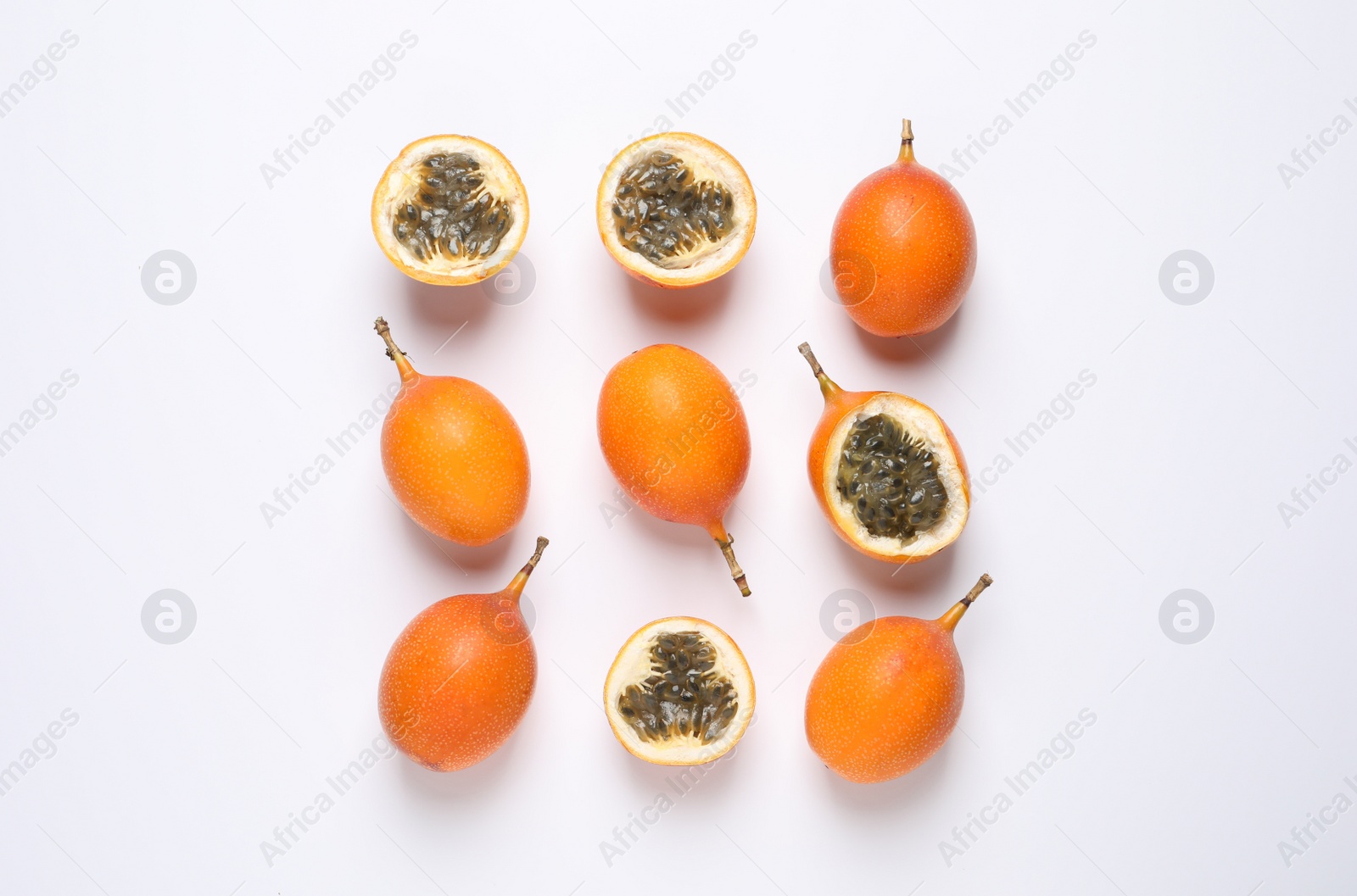 Photo of Delicious ripe granadillas on white background, flat lay