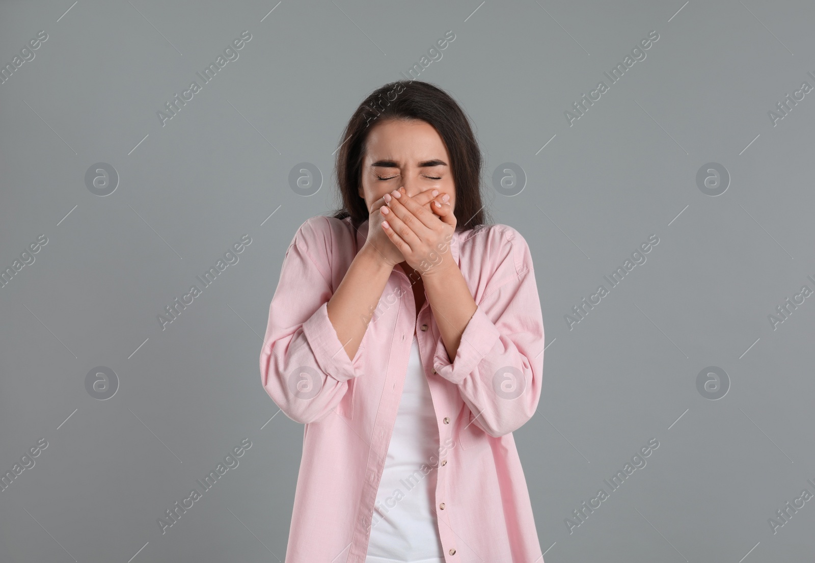 Photo of Young woman suffering from nausea on grey background. Food poisoning