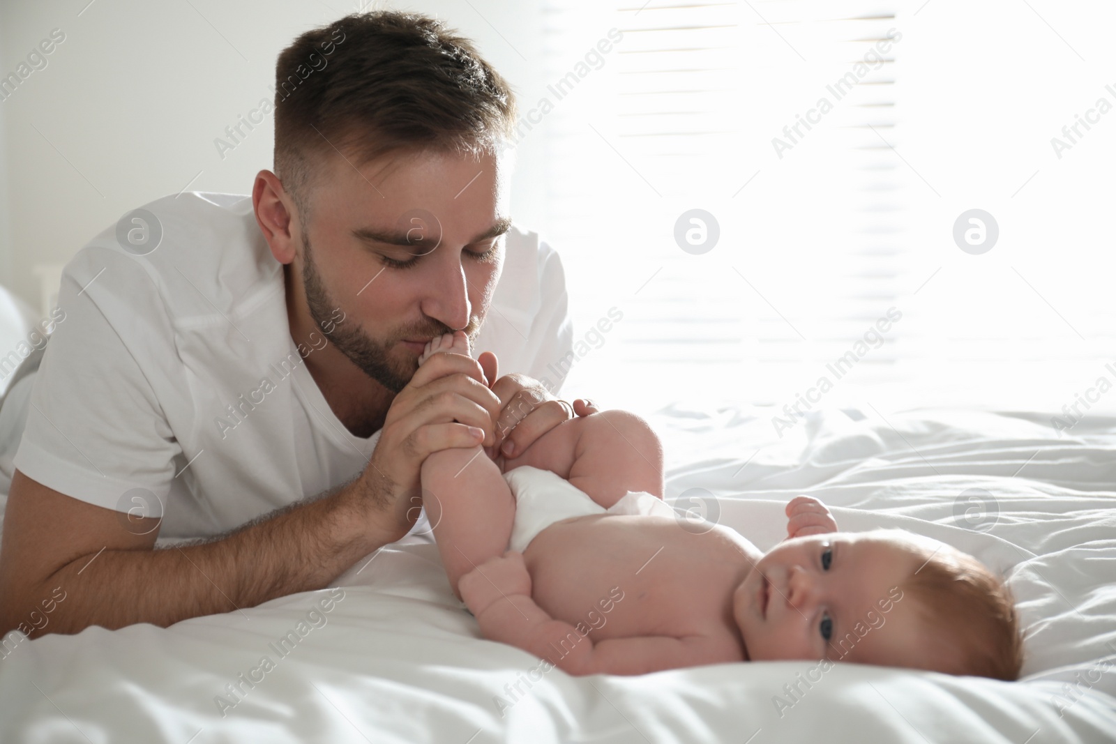 Photo of Father with his newborn son at home