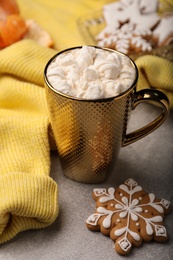 Composition with delicious marshmallow drink and yellow sweater on light grey table