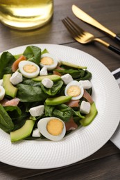 Photo of Delicious salad with boiled eggs, feta cheese and salmon on wooden table, closeup