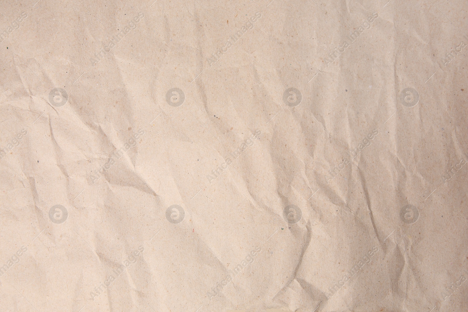 Photo of Sheet of crumpled light brown paper as background, top view