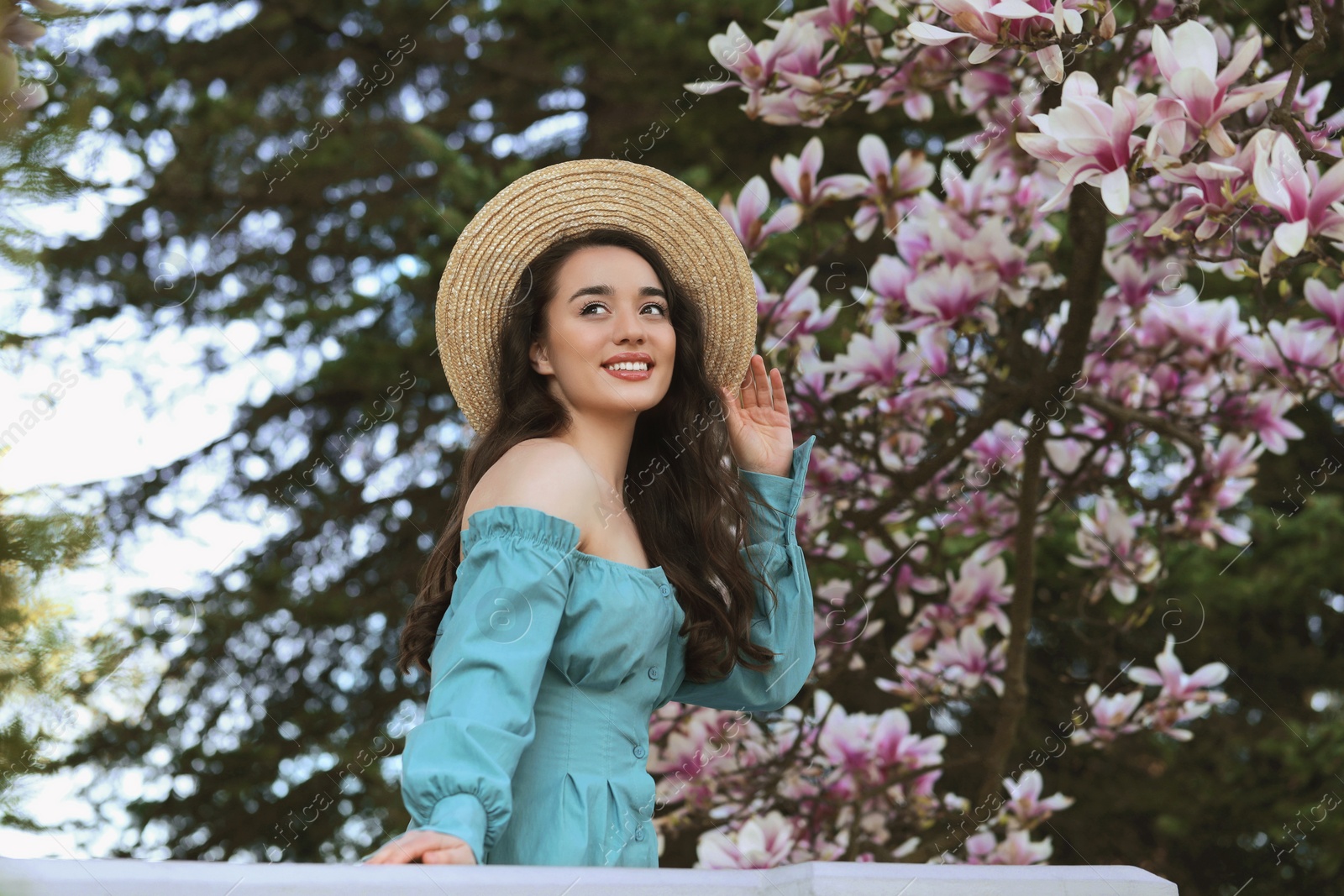 Photo of Beautiful woman near blossoming magnolia tree on spring day